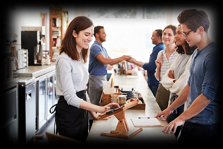 Cafe staff serving customers at a busy counter